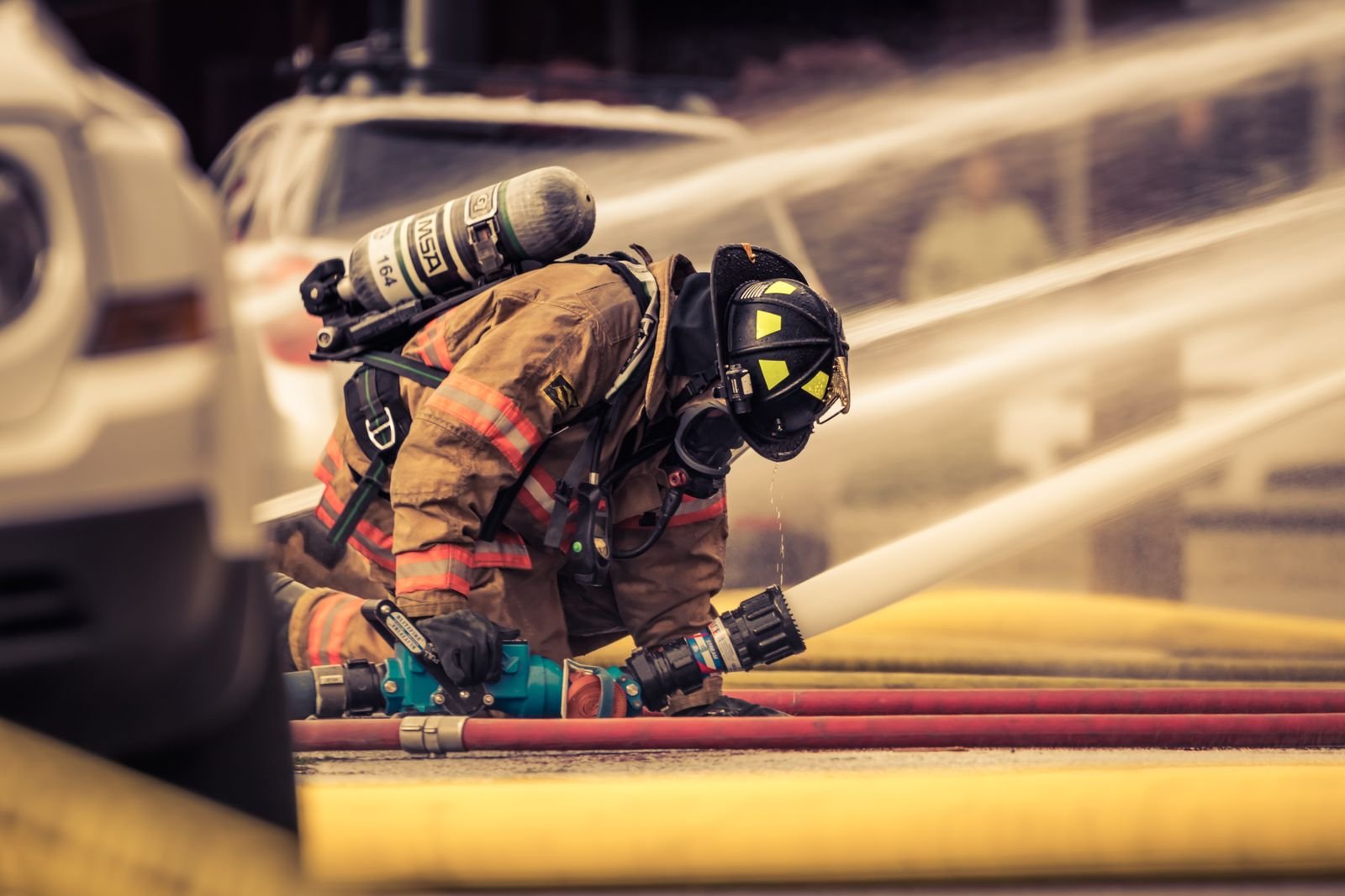 A firefighter lit by warm golden light, standing watch after the call